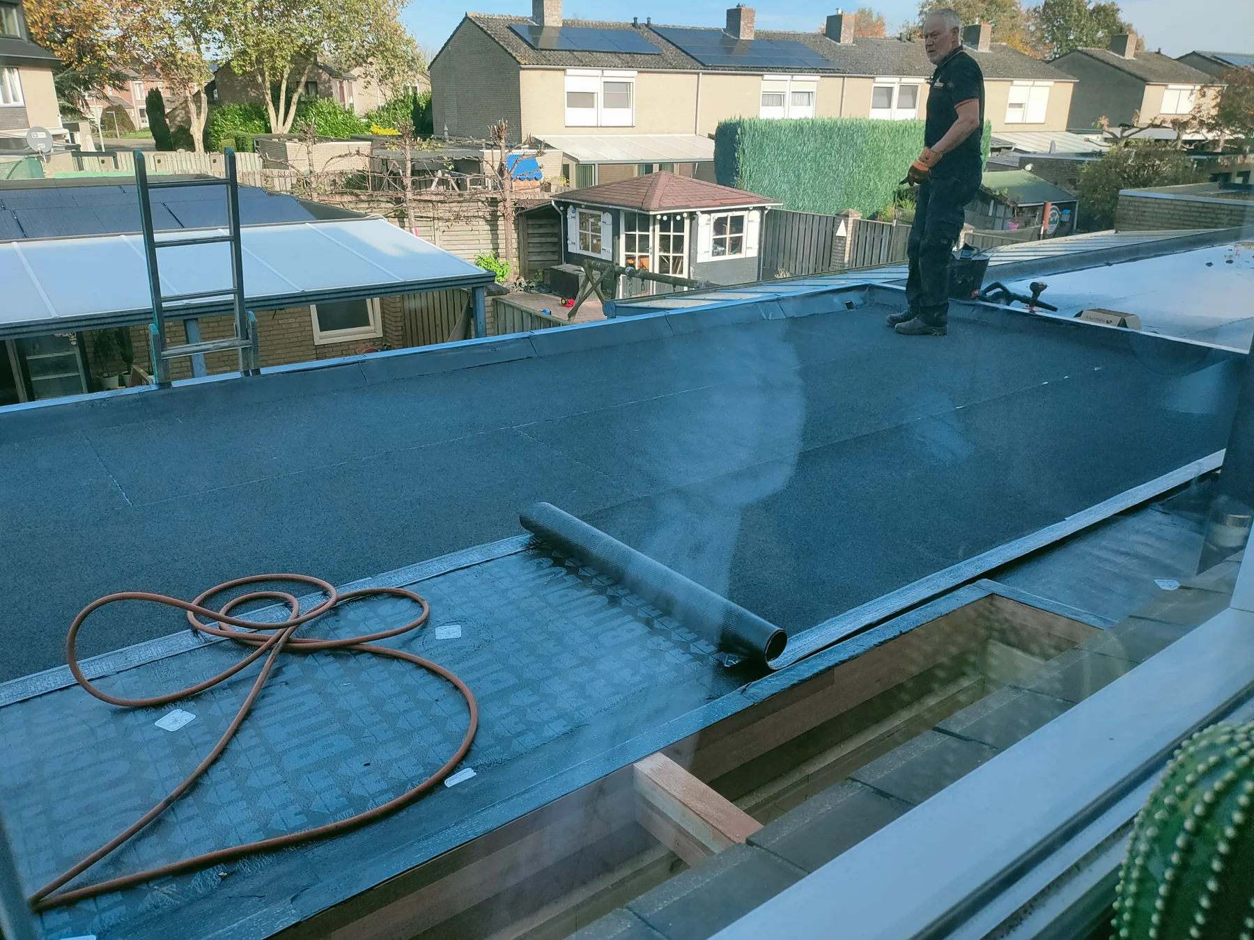 Werkzaamheden aan het platte dak van een aanbouw